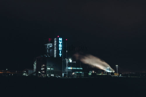 Industrial steel plant at night with illuminated tower