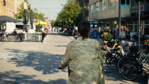 Young woman enjoys a sunny summer bike ride through Luleå