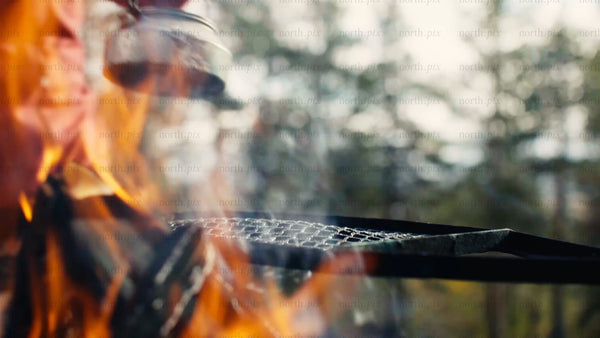 Steaming kettle on campfire grill in Luleå forest