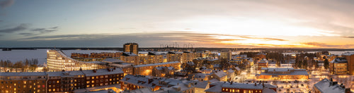 Snötäckt stadssiluett vid vintersolnedgång
