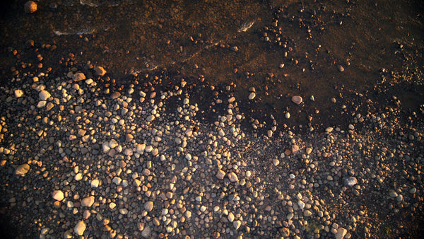 Summer evening drone shot: Waves gently washing over rocks in the rödkallen archipelago, Luleå