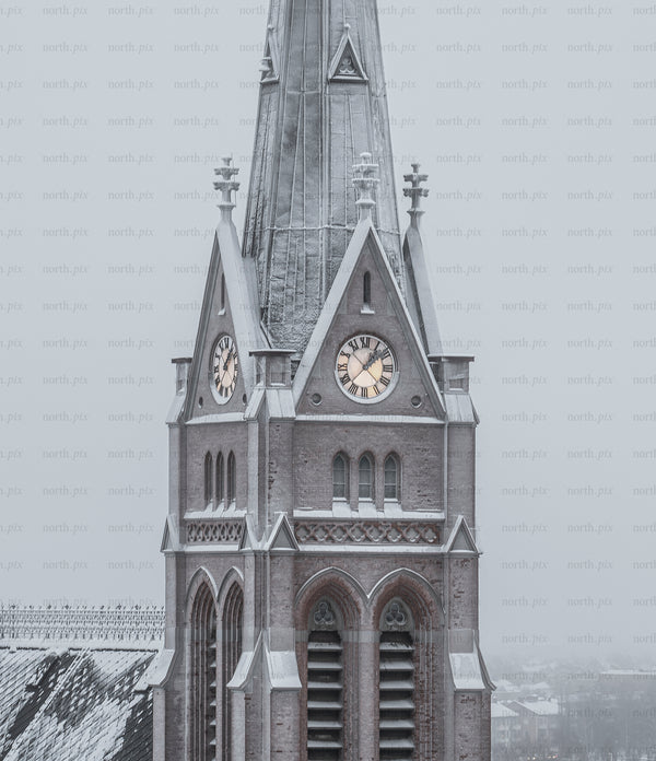 Church clock tower covered in snow on winter morning