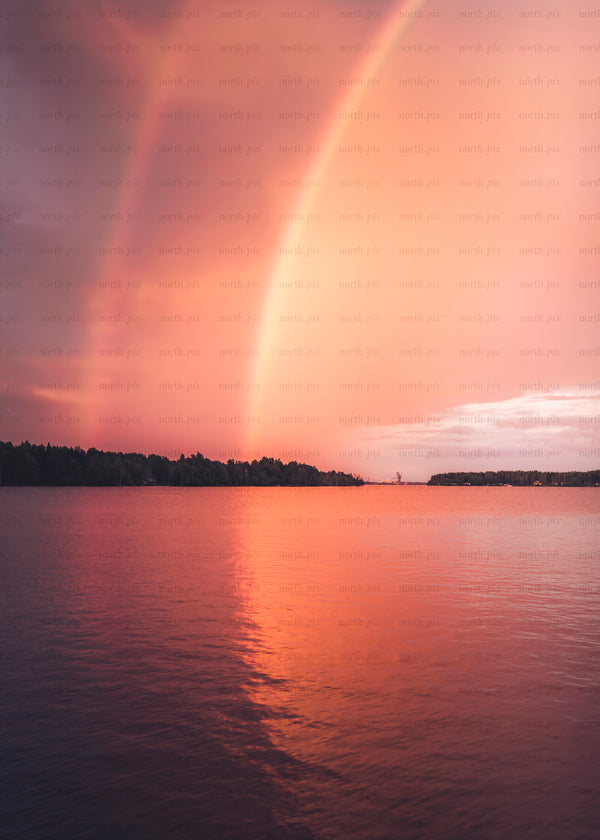 Rainbow over lake at sunset with reflection