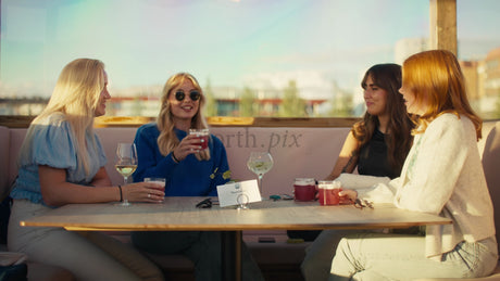 Friends Enjoy Drinks at a Rooftop Bar on a Sunny Summer Day in Lulea