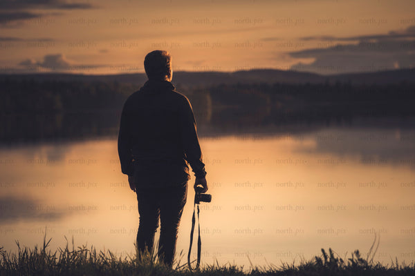 Photographer at lake at sunset