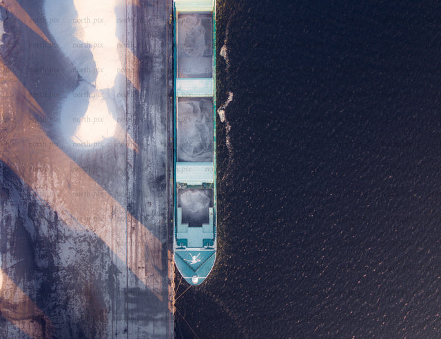 Aerial view of bulk carrier docked at quay at sunrise