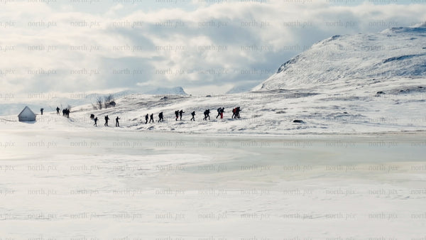 Winter hiking adventure in riksgransen, Sweden: Exploring snowy mountains and frozen lake