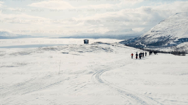 Group hiking on snowy mountain near Riksgränsen in winter