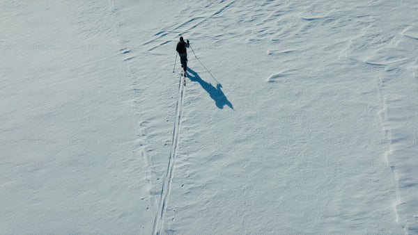 Skier crosses snowy mountain on sunny winter day