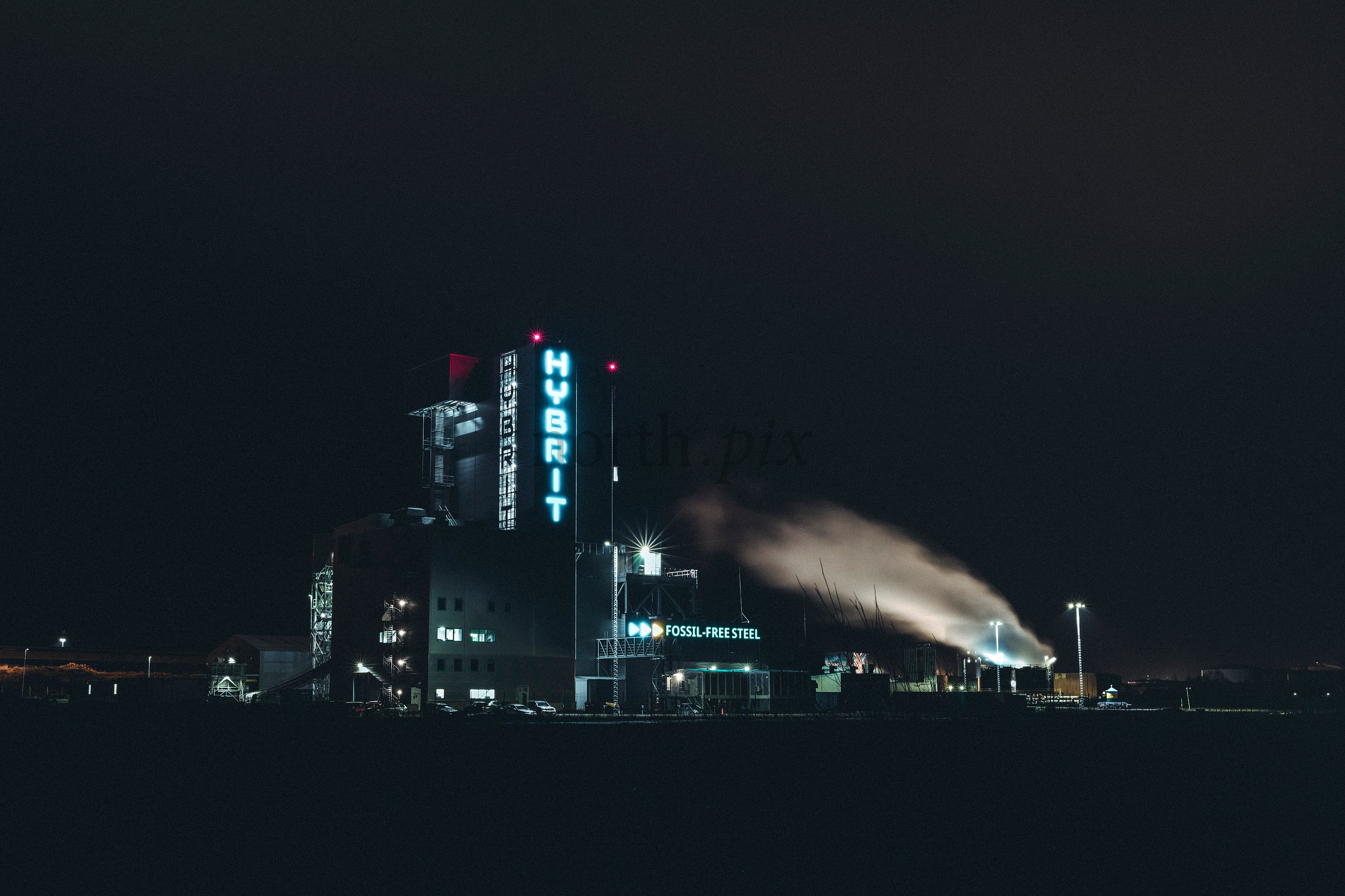Industrial plant with HYBRIT sign at night