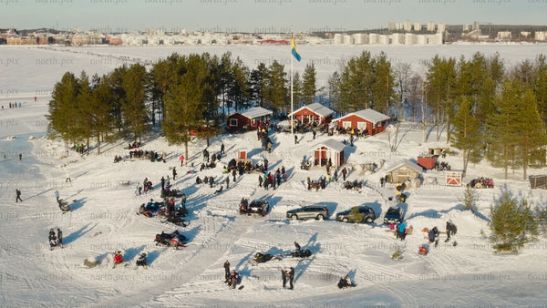 Winter gathering in Luleå: Aerial drone footage of snowy island and city skyline