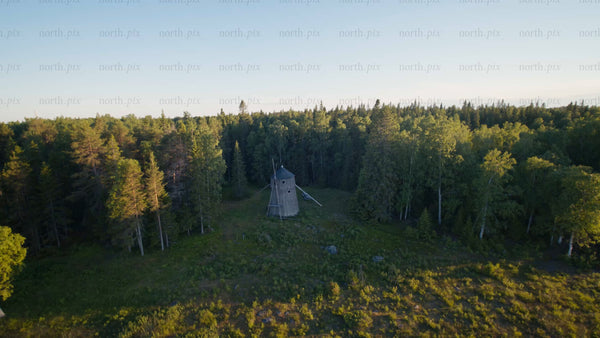 Aerial view of old windmill in forest clearing, Luleå, summer evening