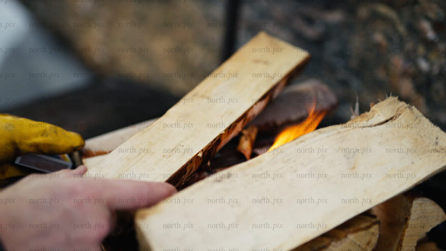 Adding firewood to a winter fire in the Luleå archipelago