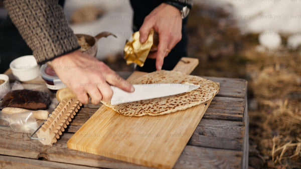 Spreading butter on fresh flatbread in wintery Luleå