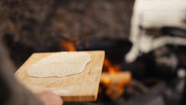 Cooking flatbread over a campfire in the Luleå archipelago, winter scene