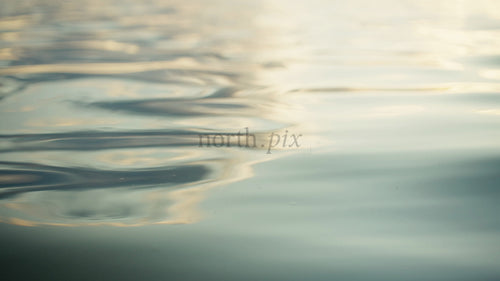 Gyllene ljus som reflekteras på lugn vattenyta