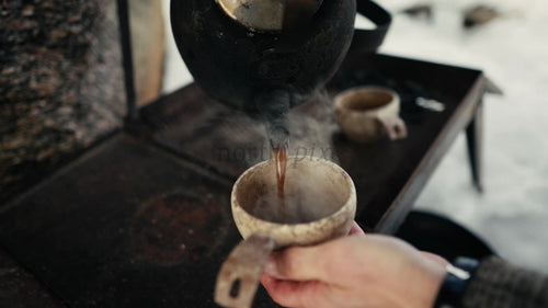Hälla varmt kaffe i Kuksa i vinterskogen i Luleå, Sverige