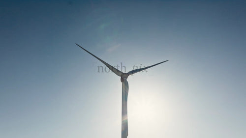 Roterande vindturbin mot blå himmel, ren energiproduktion