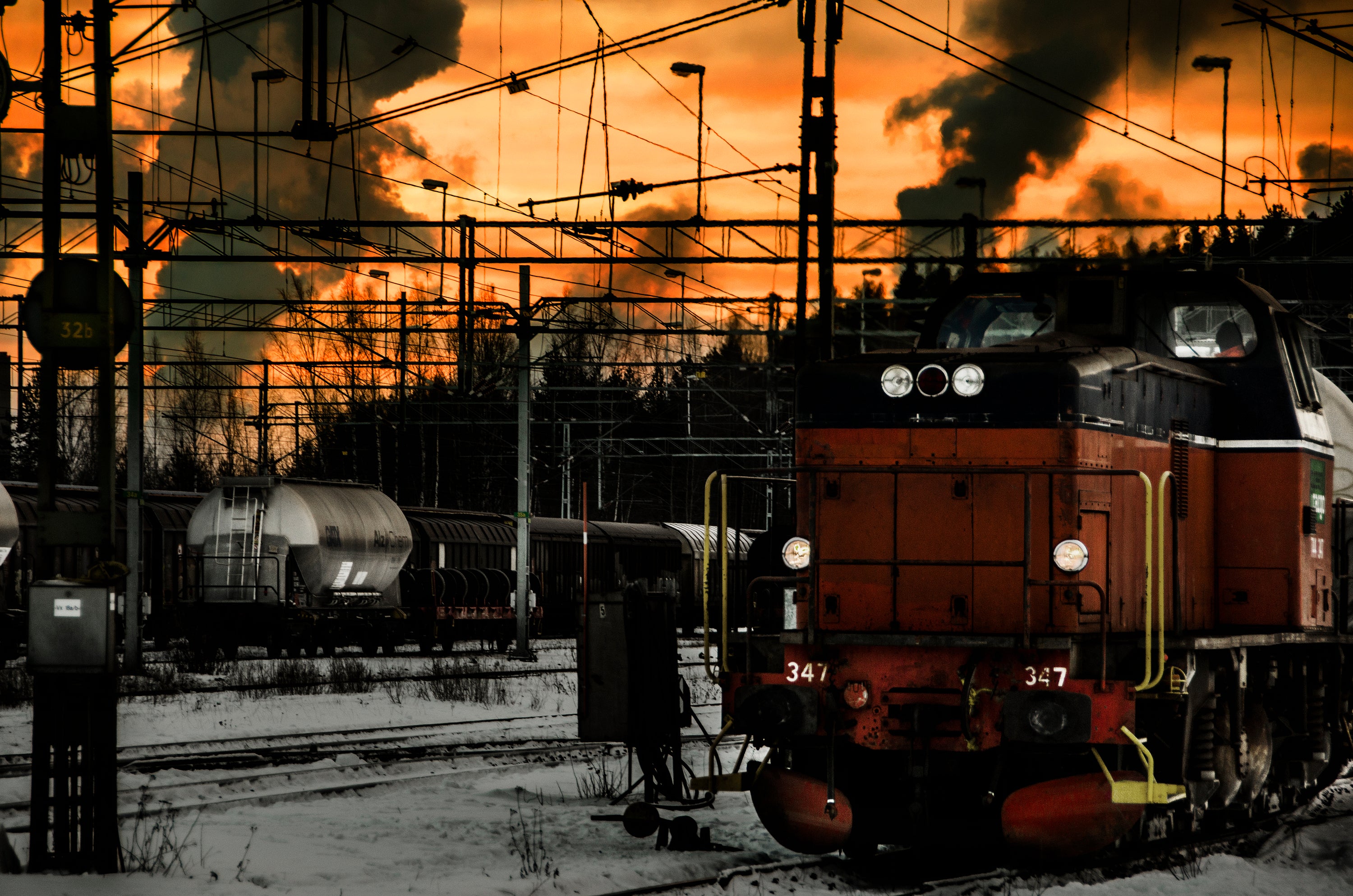 Freight locomotive in rail yard at sunset, winter