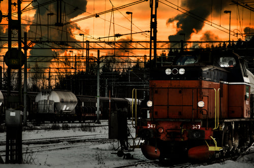 Freight locomotive in rail yard at sunset, winter