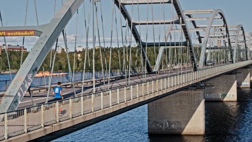 Löpare som korsar bron i Luleå, Sverige på en solig sommardag