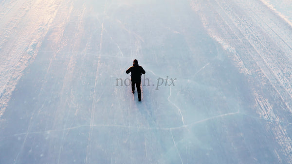 Man Kicking on Frozen Lake in Lulea, Sweden - Winter Landscape Aerial Drone View