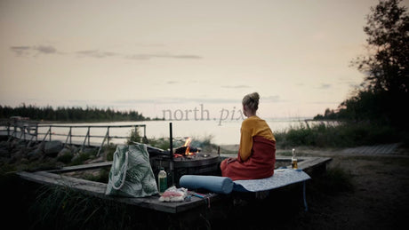Summer Evening in the Luleå Archipelago: Woman Relaxes by Campfire at Twilight