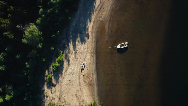 Summer day in Luleå archipelago: Aerial view of beach, boat, and people