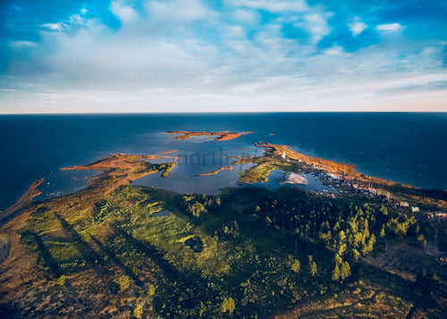 Naturskön drönarvy över kustöar vid solnedgången med skog och vatten