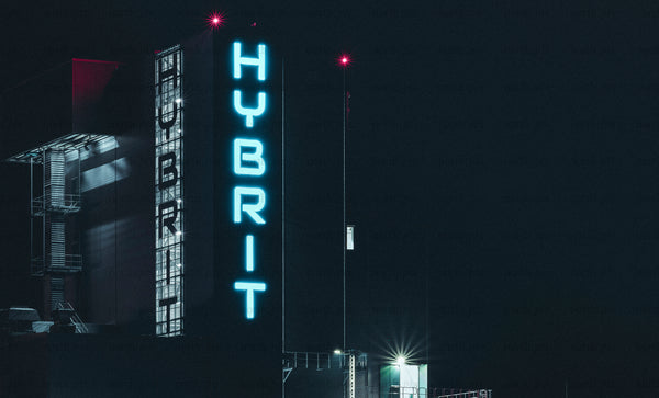 Hybrit neon sign on industrial building at night
