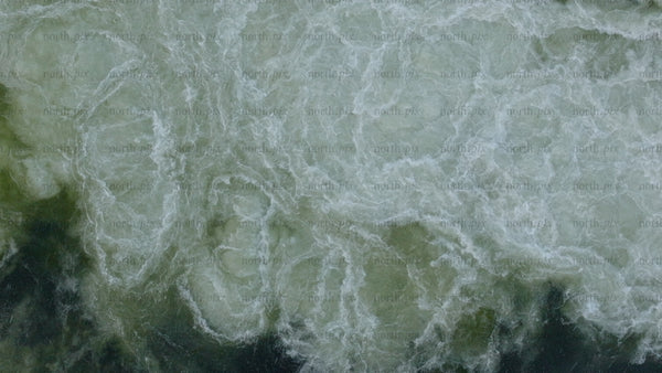 Aerial view of hydro power station dam releasing water in winter