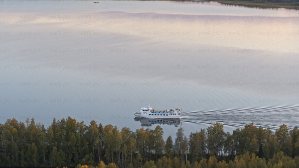 Luleå: Sunset ferry across the calm lake in summer
