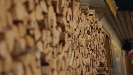 Man Selecting Firewood Logs From an Outdoor Woodpile in Daylight