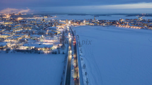 Skymningstidsförlopp i snötäckta Luleå på vintern: Bilar på vägar, frusen vik