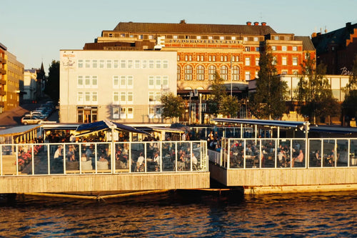 Utomhusmatsal vid floden i Luleå centrum med glasväggig terrass över vattnet