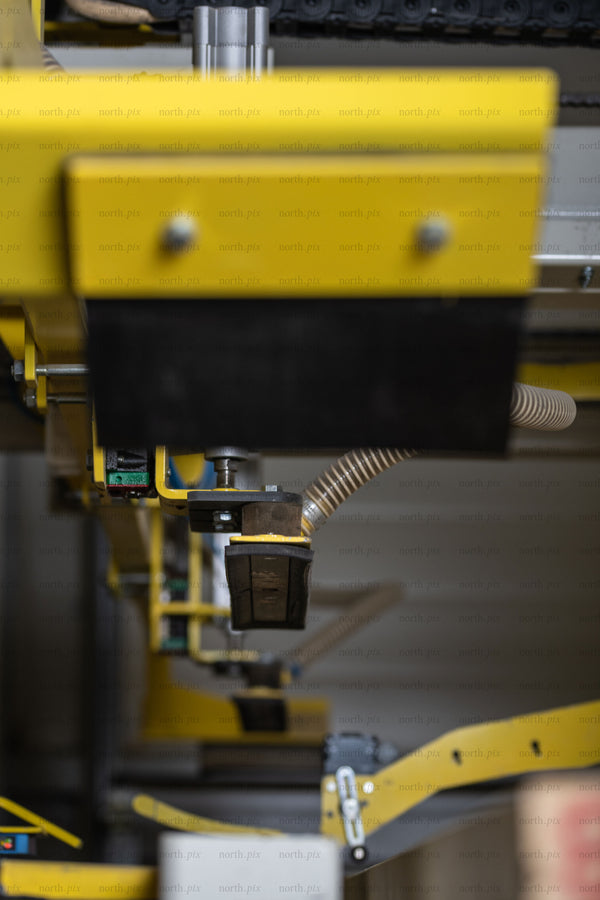 Close-up of yellow conveyor gripper in factory
