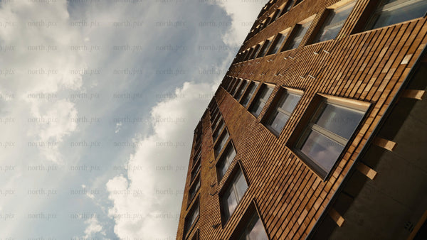 Modern wood architecture: Sliding shot of multi-story residential building with cloudy sky