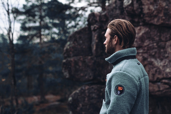 Man in fleece jacket in rocky forest, autumn