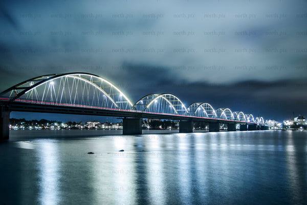 Illuminated arch bridge at night over river