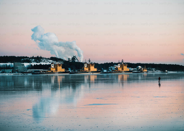 Winter evening in Luleå harbor with industrial ships and skating activity