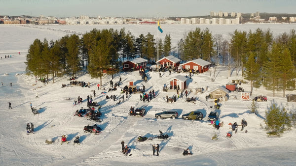 Winter gathering in Luleå: Aerial drone footage of snowy island and city skyline