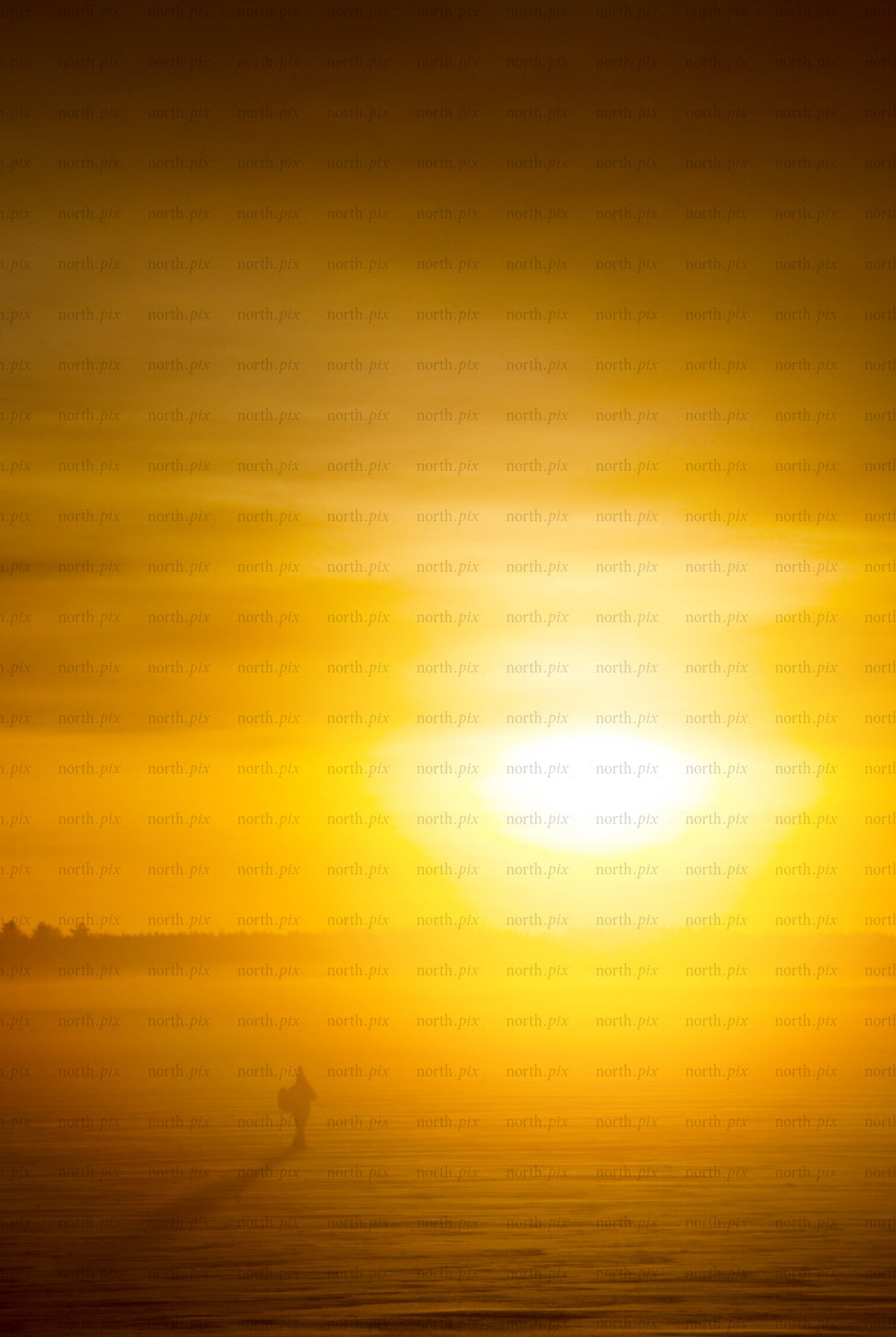 Man silhouette walking on frozen lake at sunrise