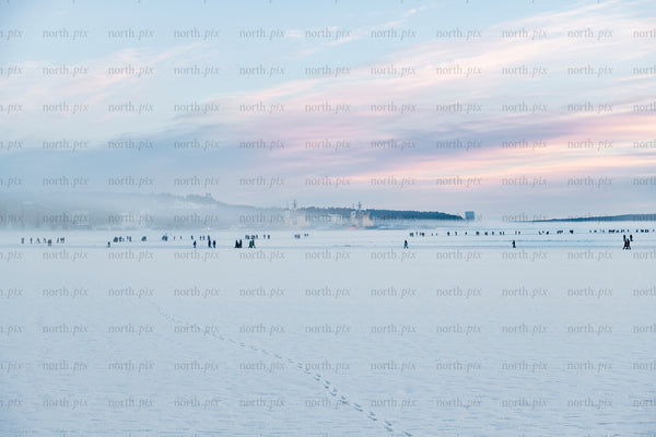 People on frozen sea at sunrise, winter