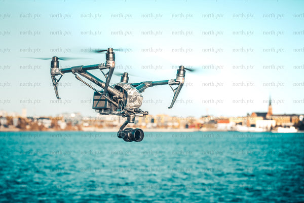Drone camera flying over waterfront city at midday