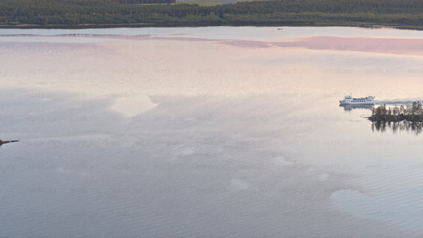 Luleå summer sunset: Ferry and boat on calm lake with scenic reflections