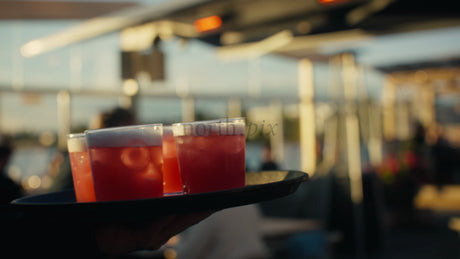 Waiter Carries Cocktails at Sunset Restaurant in Lulea Urban Summer