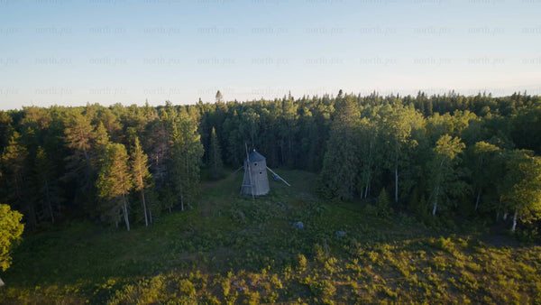 Aerial view of old windmill in forest clearing, Luleå, summer evening