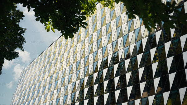 Modern geometric wood building exterior with triangular glass facade and upward camera movement