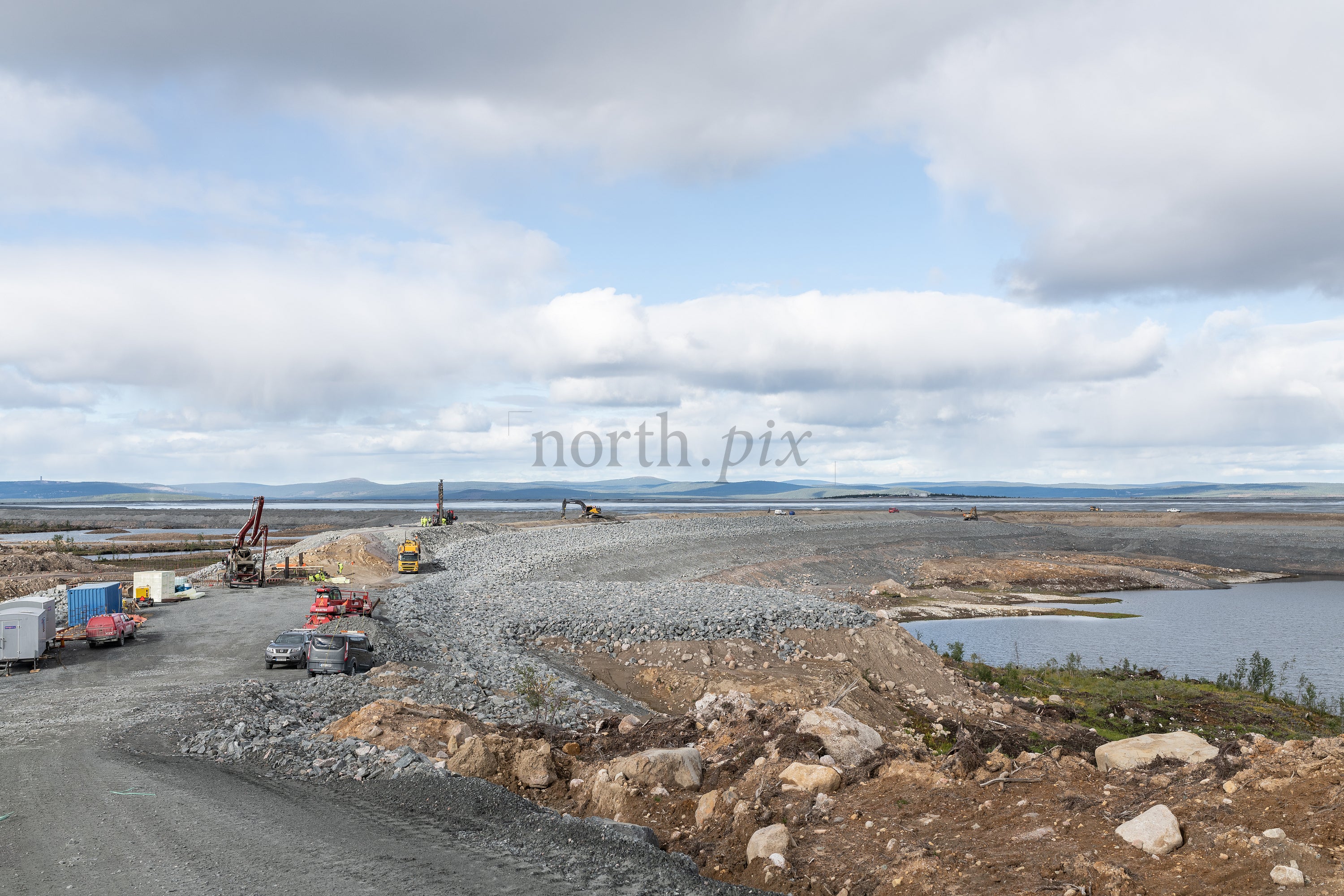 Construction site with gravel causeway on overcast day