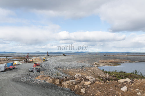 Construction site with gravel causeway on overcast day